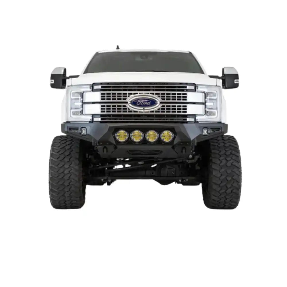 White Ford pickup truck with custom off-road bumper and large tires